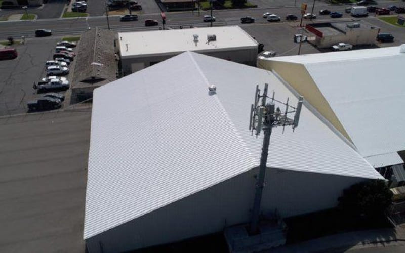 An aerial view of a building with a white commercial roof.