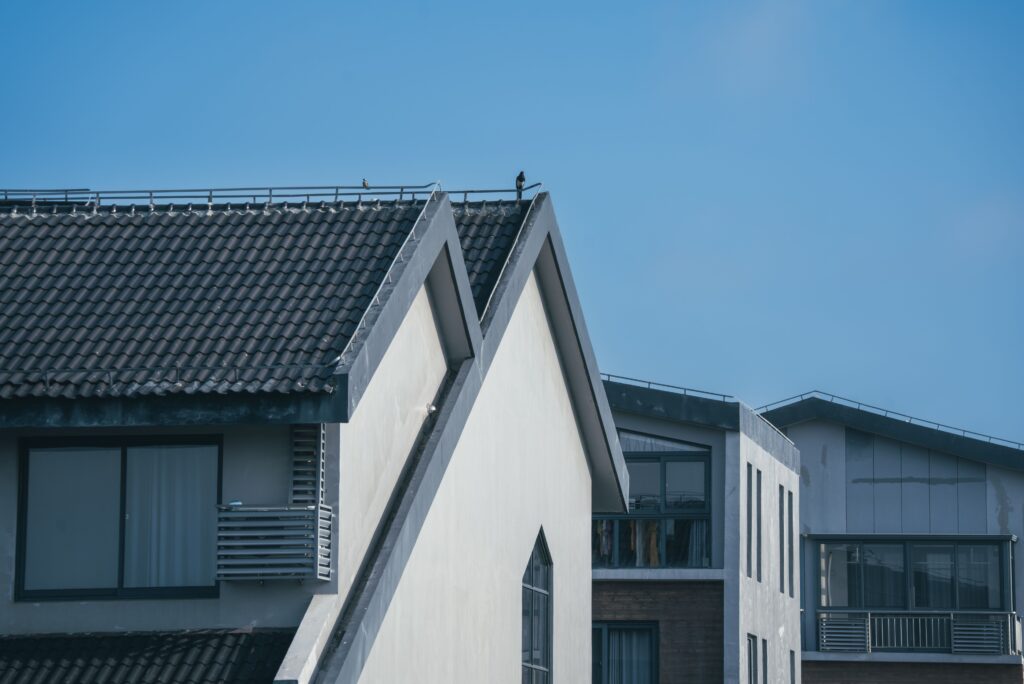 Modern residential buildings with varied geometric rooflines set against a clear blue sky